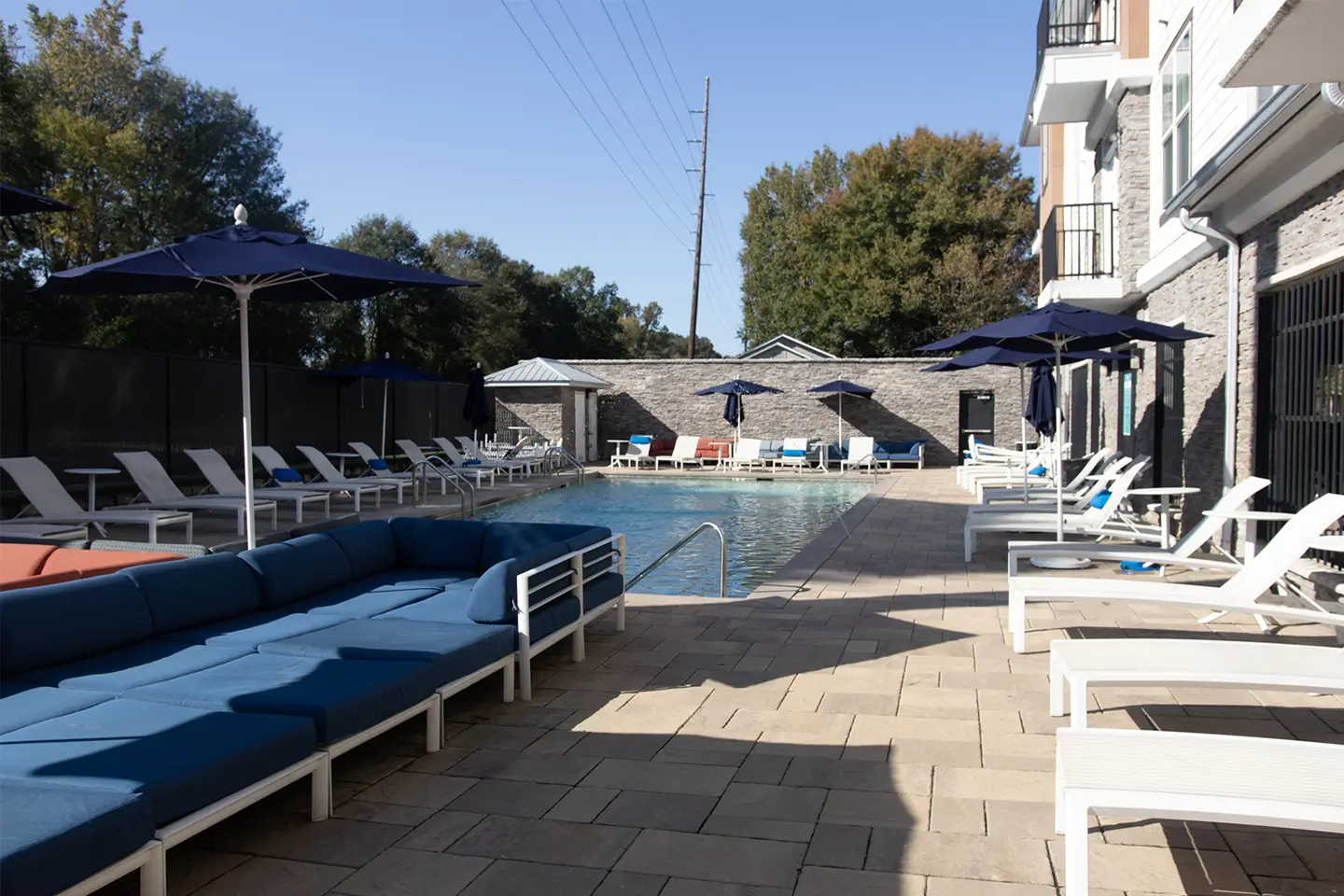 Swimming pool surrounded by lounge chairs and umbrellas.